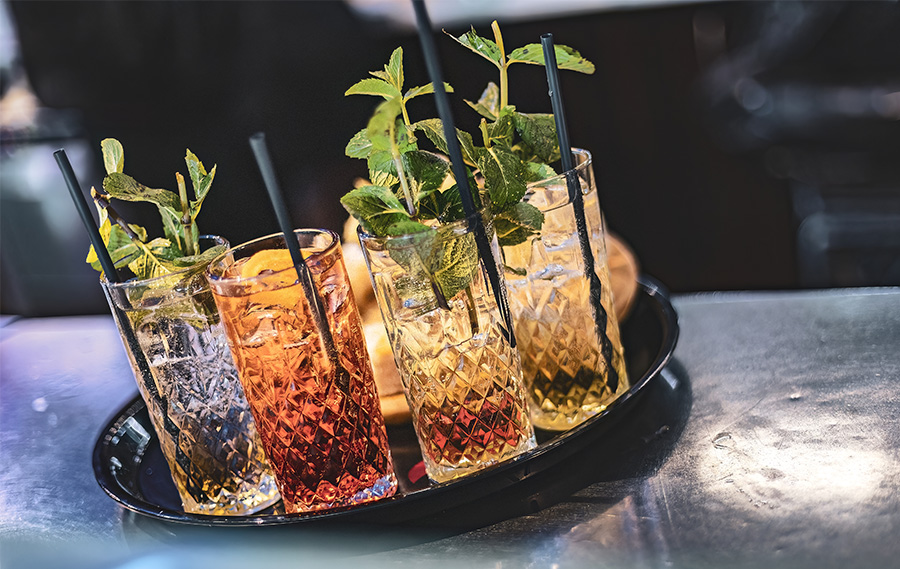 Close-Up of Beautifully Crafted Drinks in Crystal Glasses Zwei Leute stoßen mit ihren Cocktails an